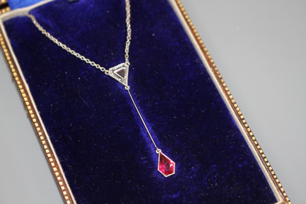 An Art Deco style white metal, ruby and diamond set drop pendant necklace, pendant section 40mm, gross weight 3.9 grams.
